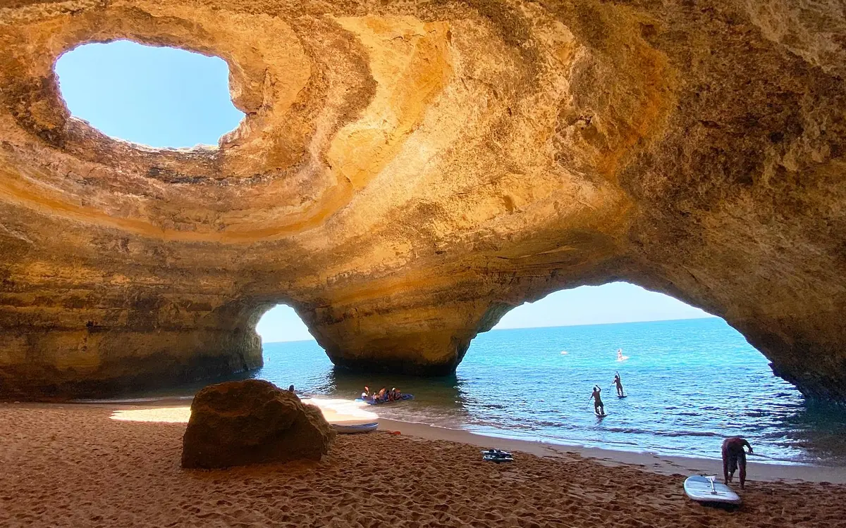 A sandy beach below an arch in the Algarve cliffs