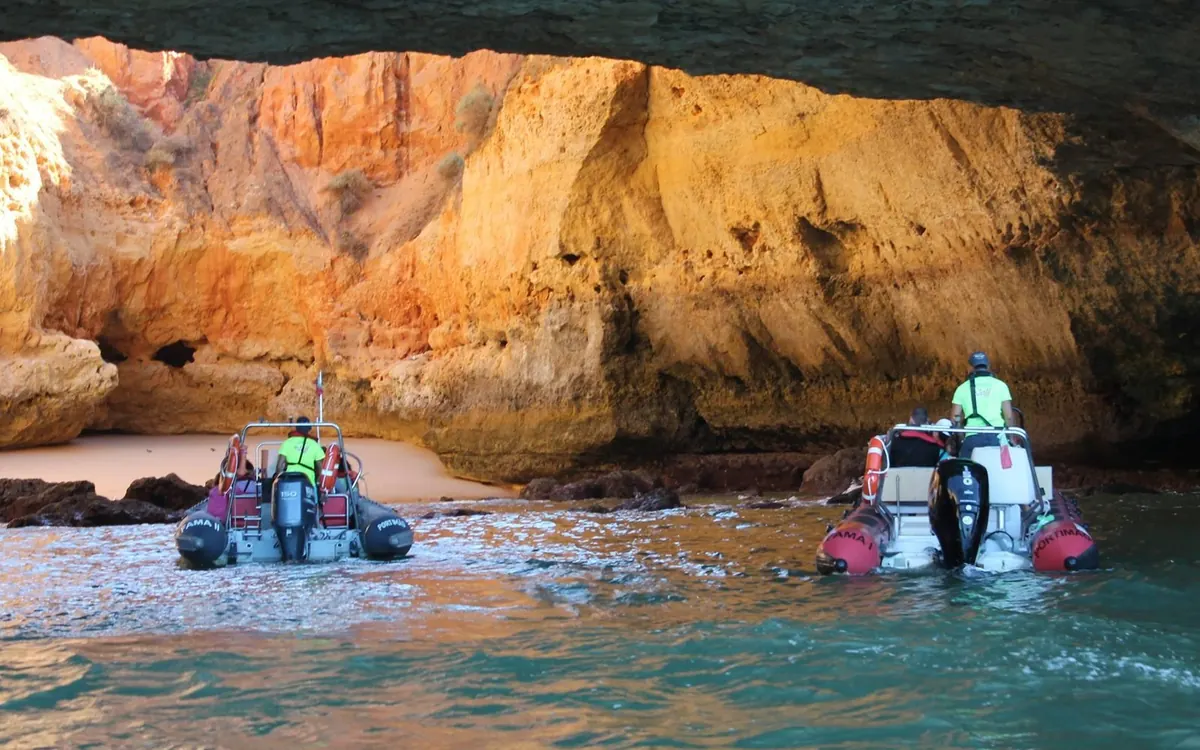 A small boat inside a Benagil sea cave with light on the rock