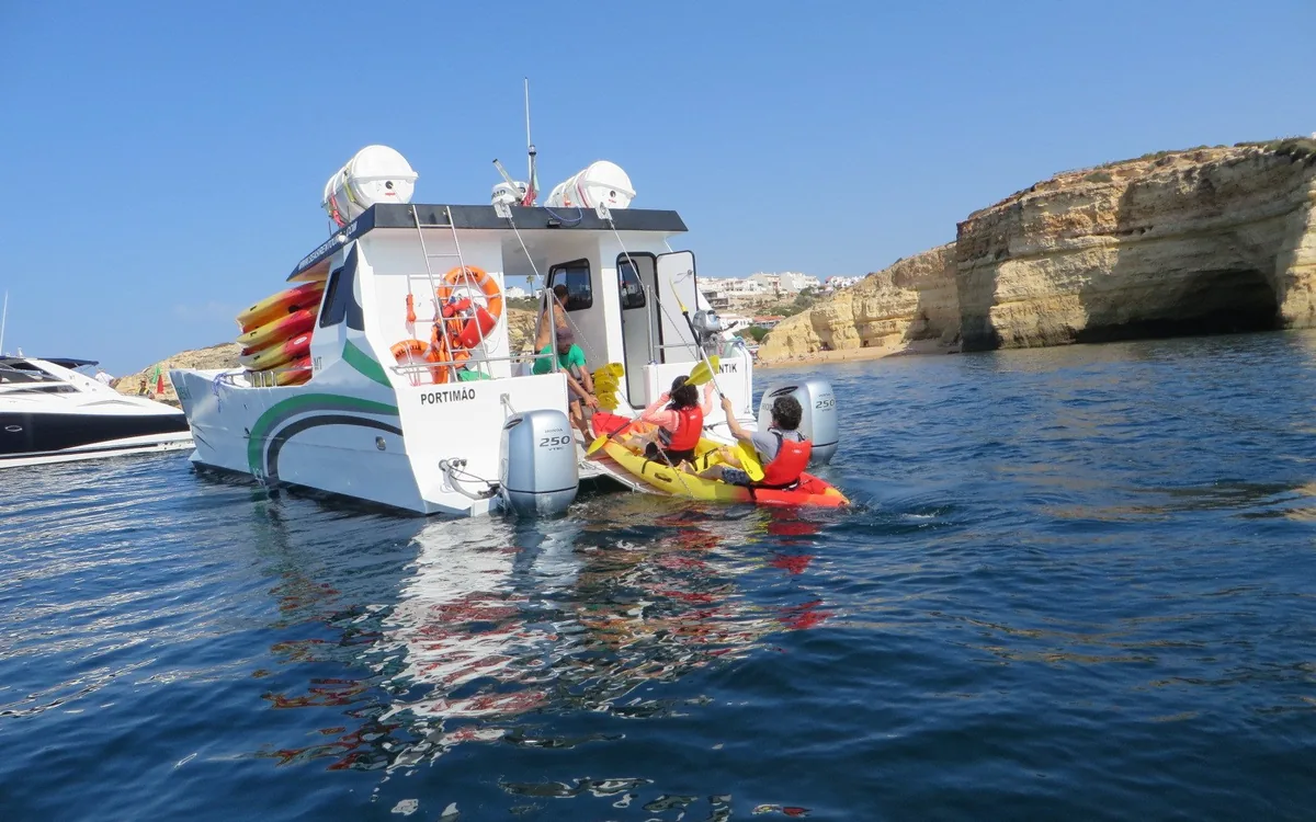 A guided kayak group entering a sea cave on the Algarve coast