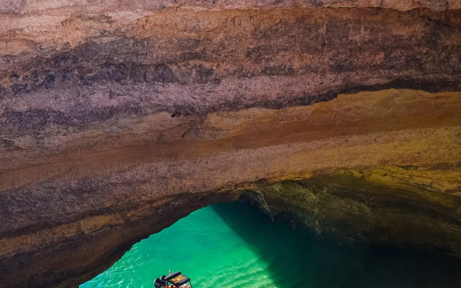 The green water and layered rock inside a Benagil sea cave