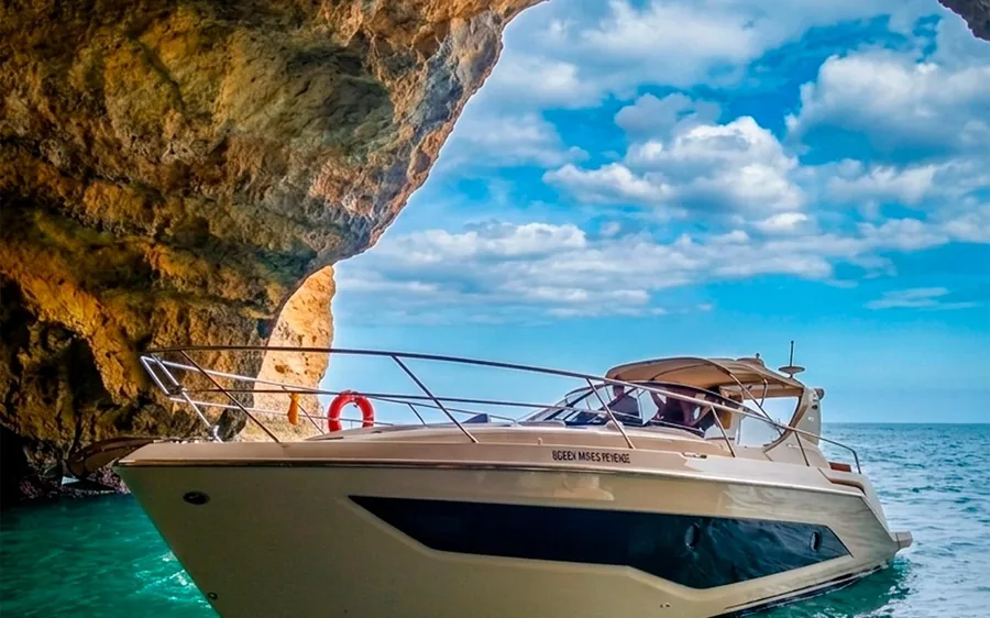 A private yacht moored beside the cliffs at Benagil